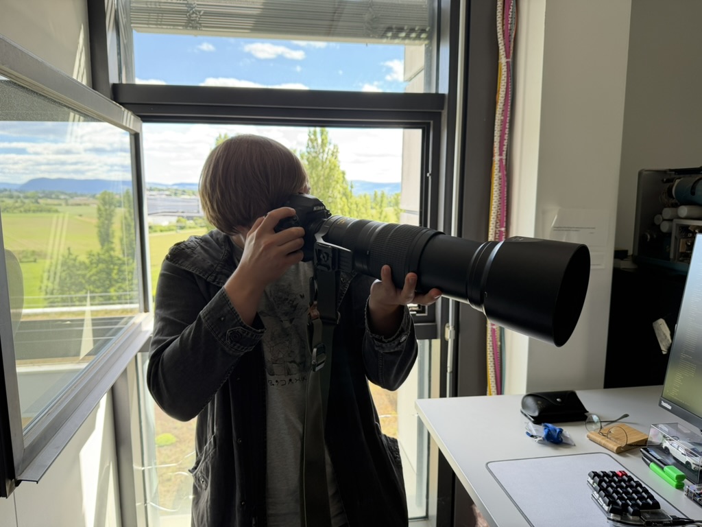 Tom James looking through a camera with a long wildlife lens